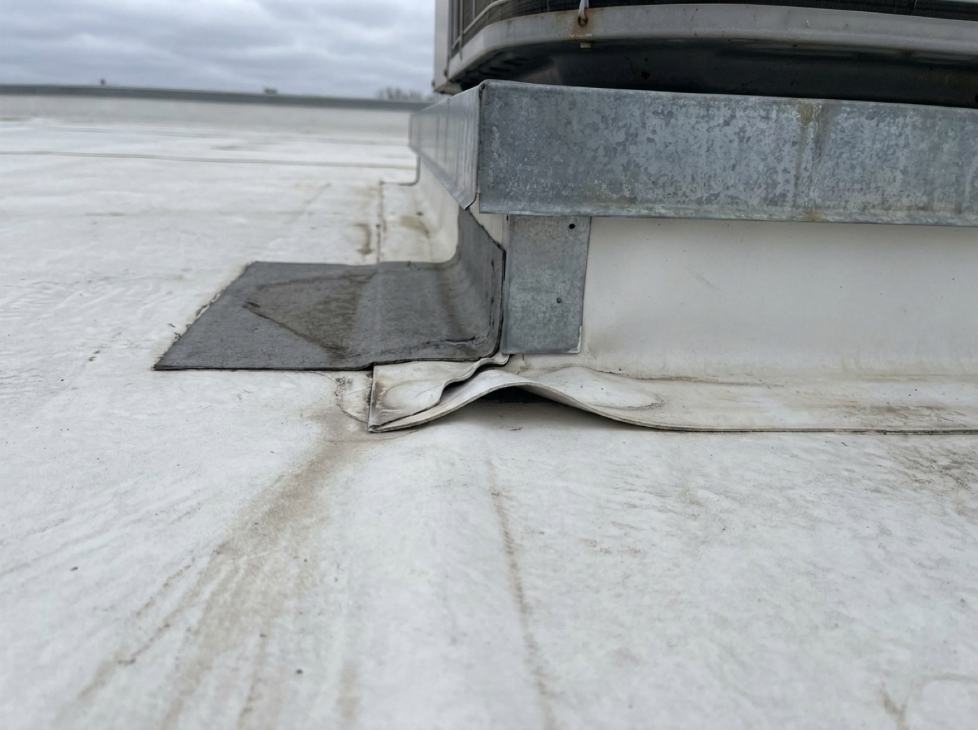Roof — seam failure at HVAC curb over aisle 14
